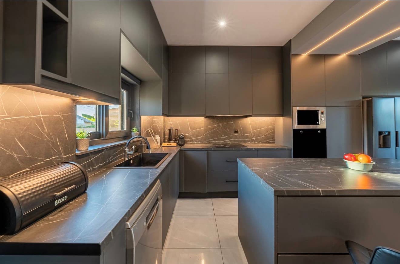 Modern kitchen with dark veined stone countertops and integrated cabinetry